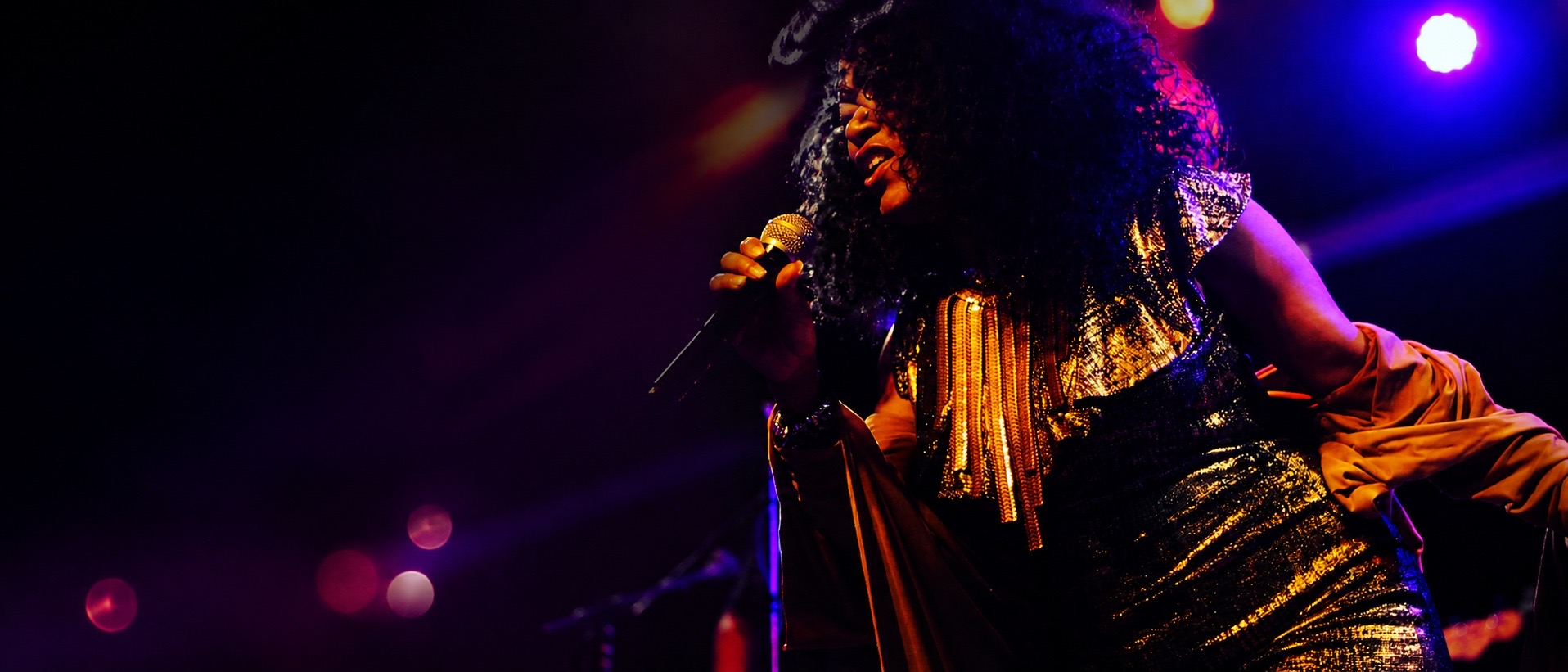 Tonia Ray performing live on stage with a microphone